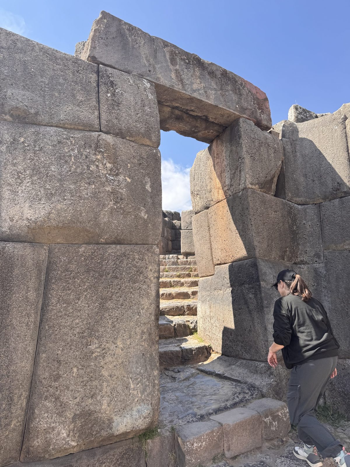 A trapezoidal Inca doorway at Sacsayhuamán with a stairway beyond